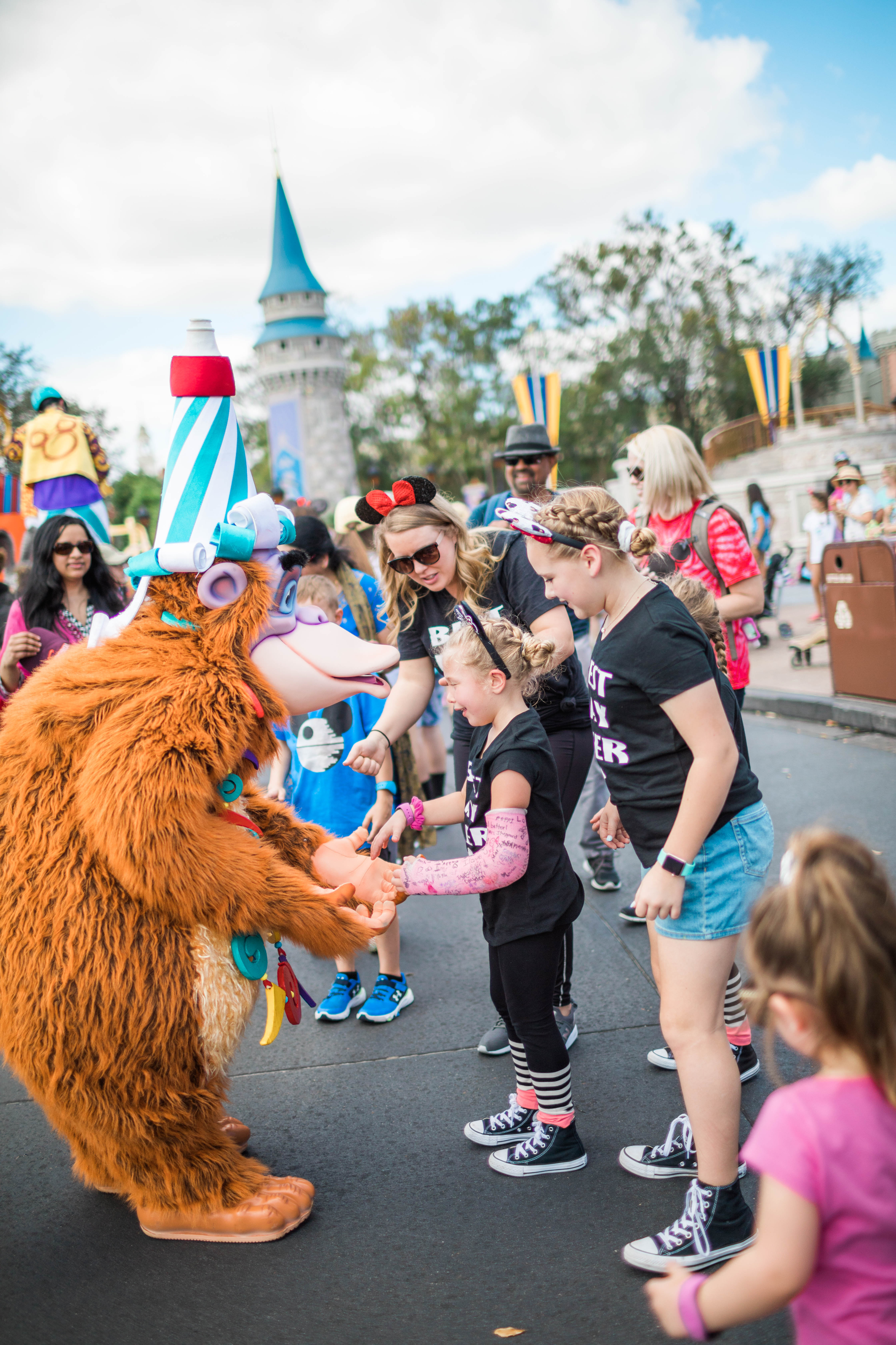 Kids, Mom and Characters dancing in the street at Disney World